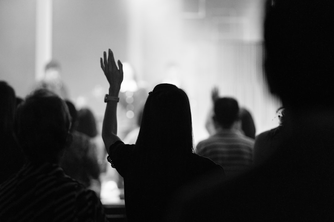 Worship gathering with a raised hand